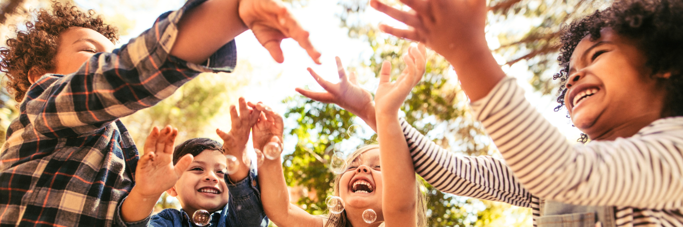 Kinder spielen mit Seifenblasen