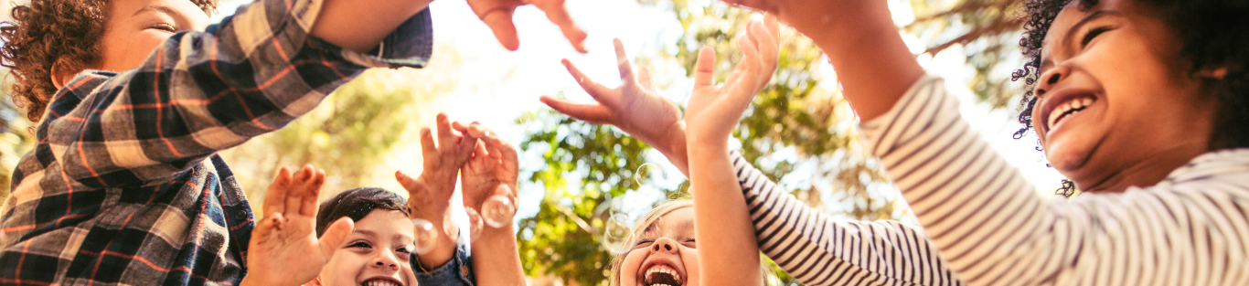 Kinder spielen mit Seifenblasen