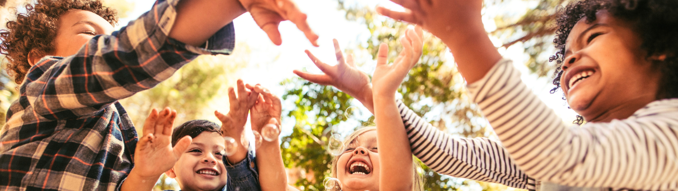 Kinder spielen mit Seifenblasen