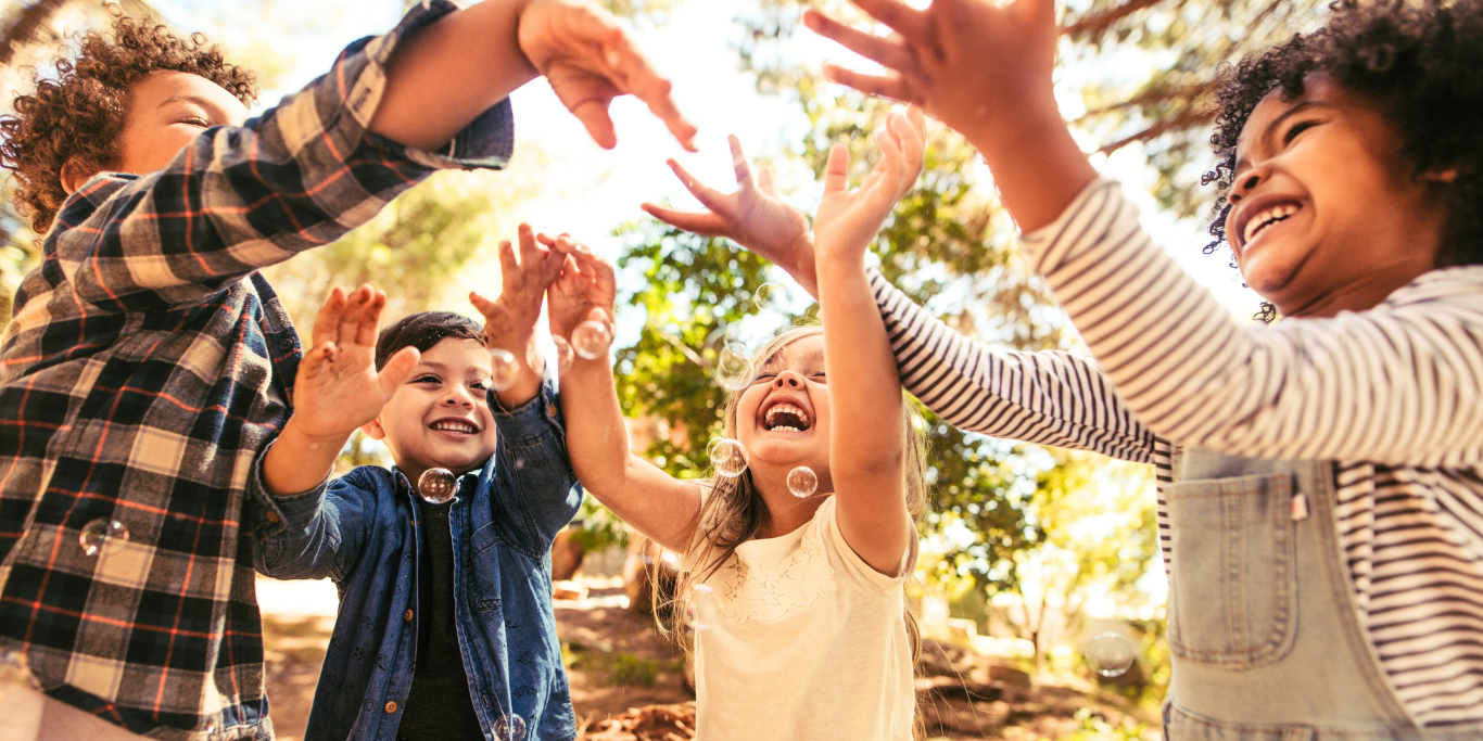 Kinder spielen mit Seifenblasen