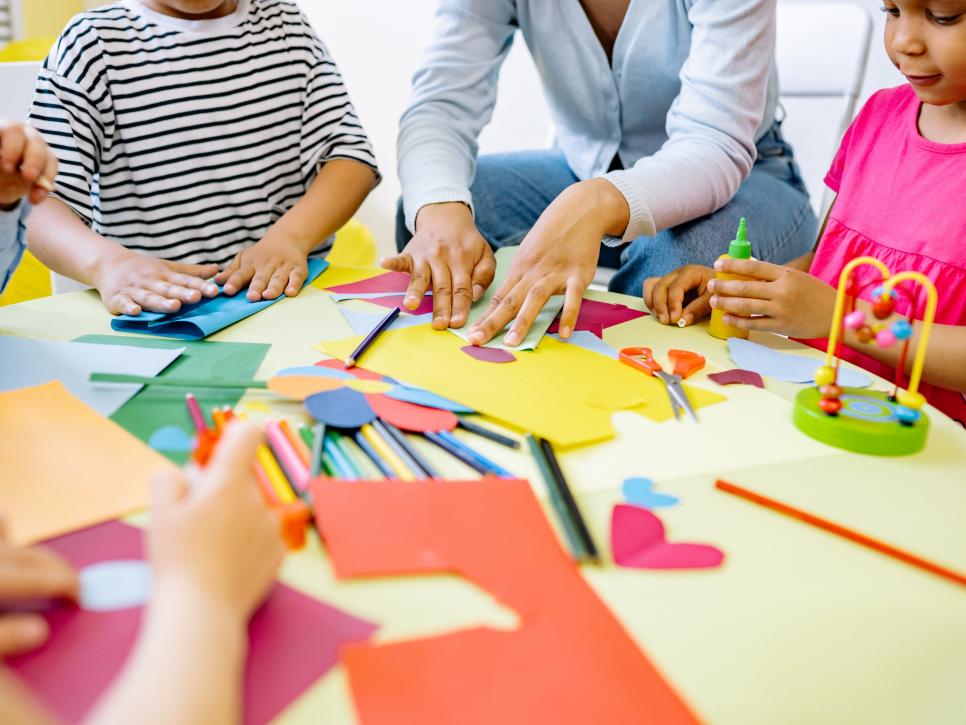 Bastelnde Kinderhände am Tisch